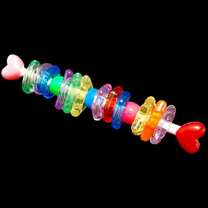 A rolled paper lollipop stick filled with pony beads and brightly colored rings of different shapes. When your bird holds or shakes this toy, it sounds like a rainstick! Designed for small to intermediate birds as well as larger birds that like to fidget with smaller toys.